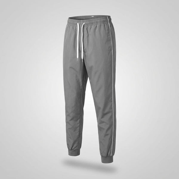Calça tactel masculina cinza, still de frente com fundo gradiente neutro, cordão branco e friso lateral, sem modelo